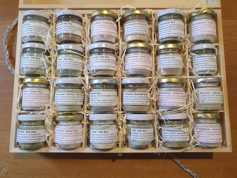 Holzbox mit 24 Unterteilungen mit 24 Gläsern Kräutersalz befüllt. 